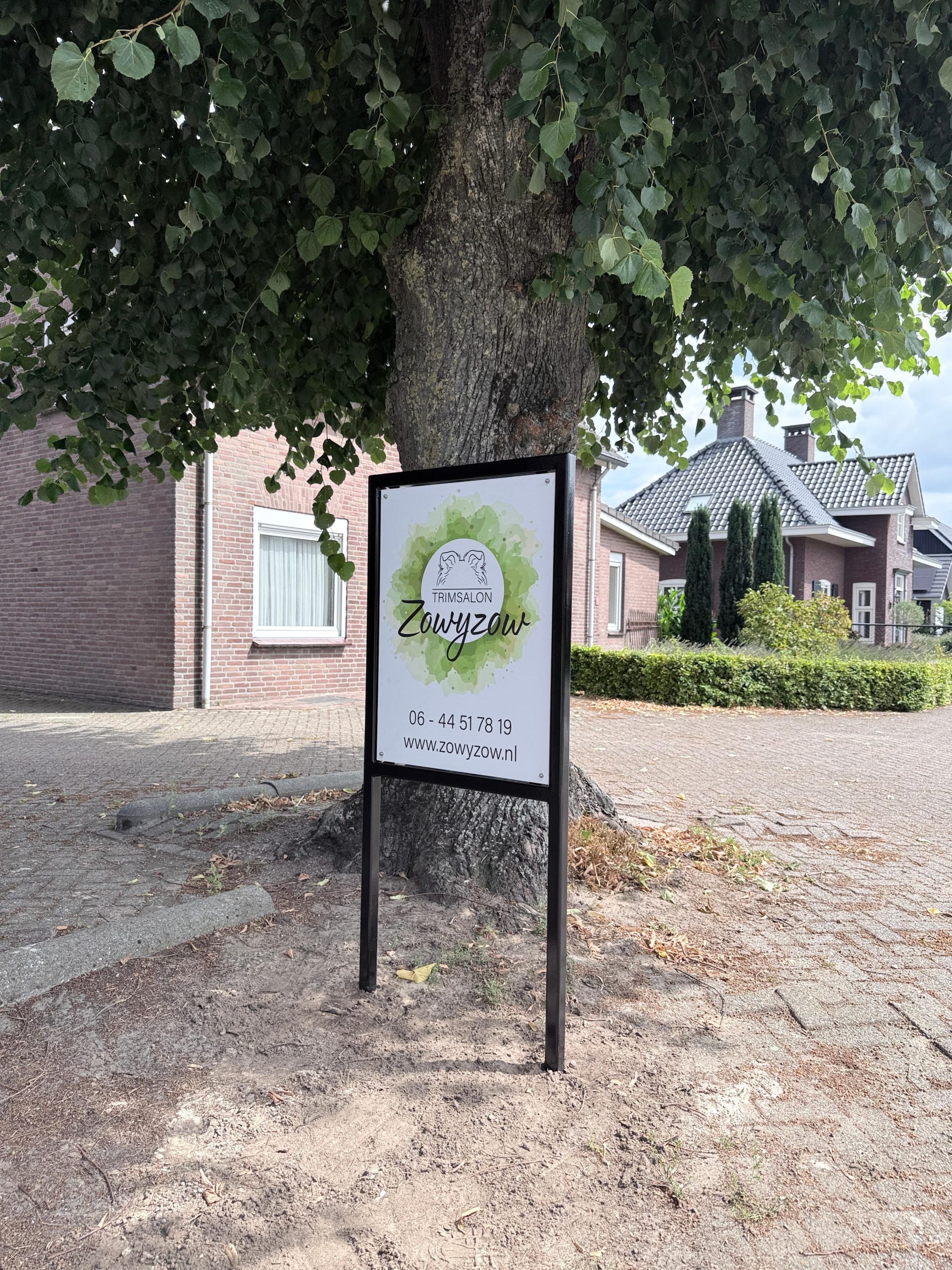 Reclamebord Zowyzow aan de weg, onder de boom